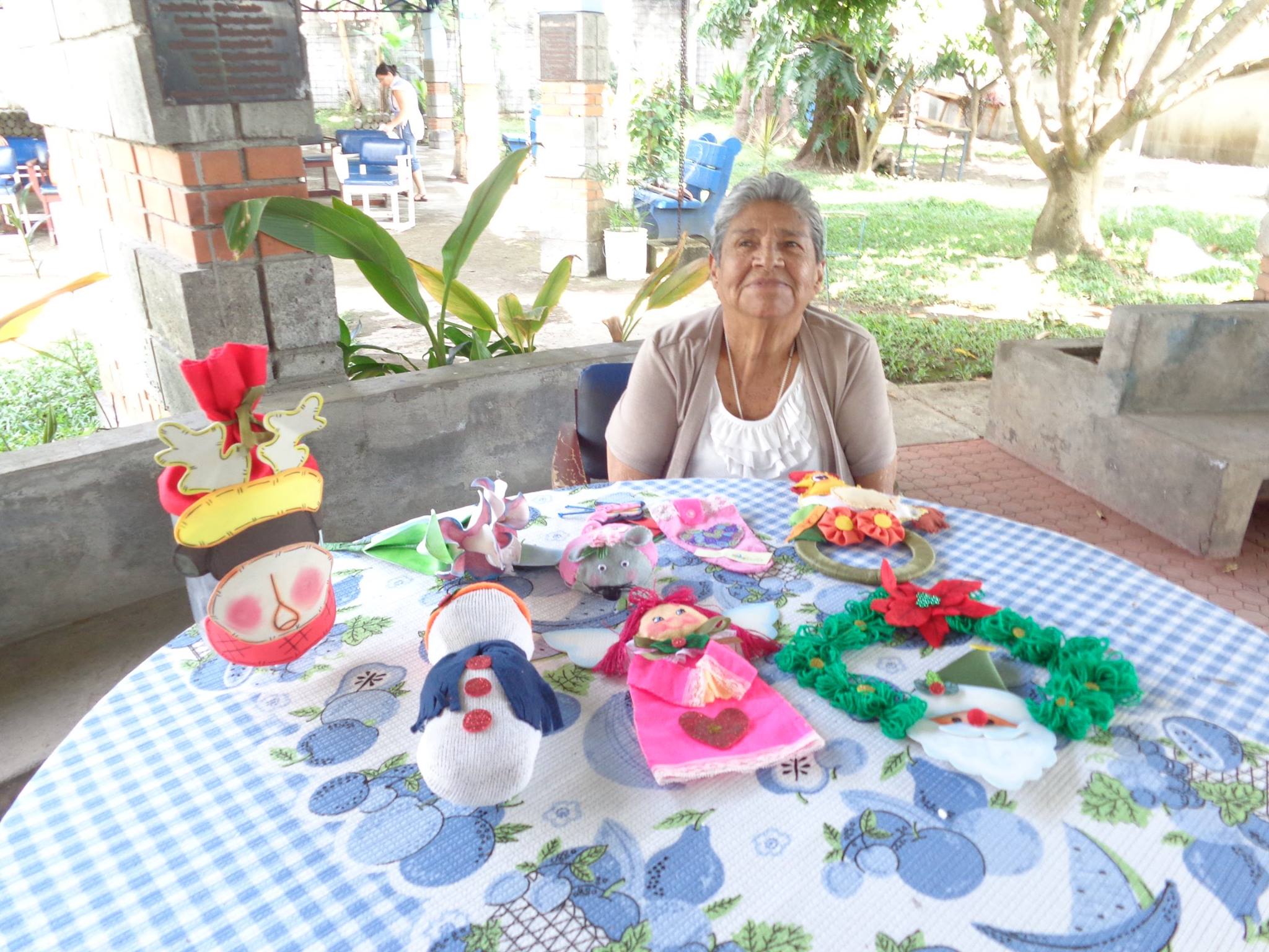 Adulta mayor sentada junto a sus manualidades